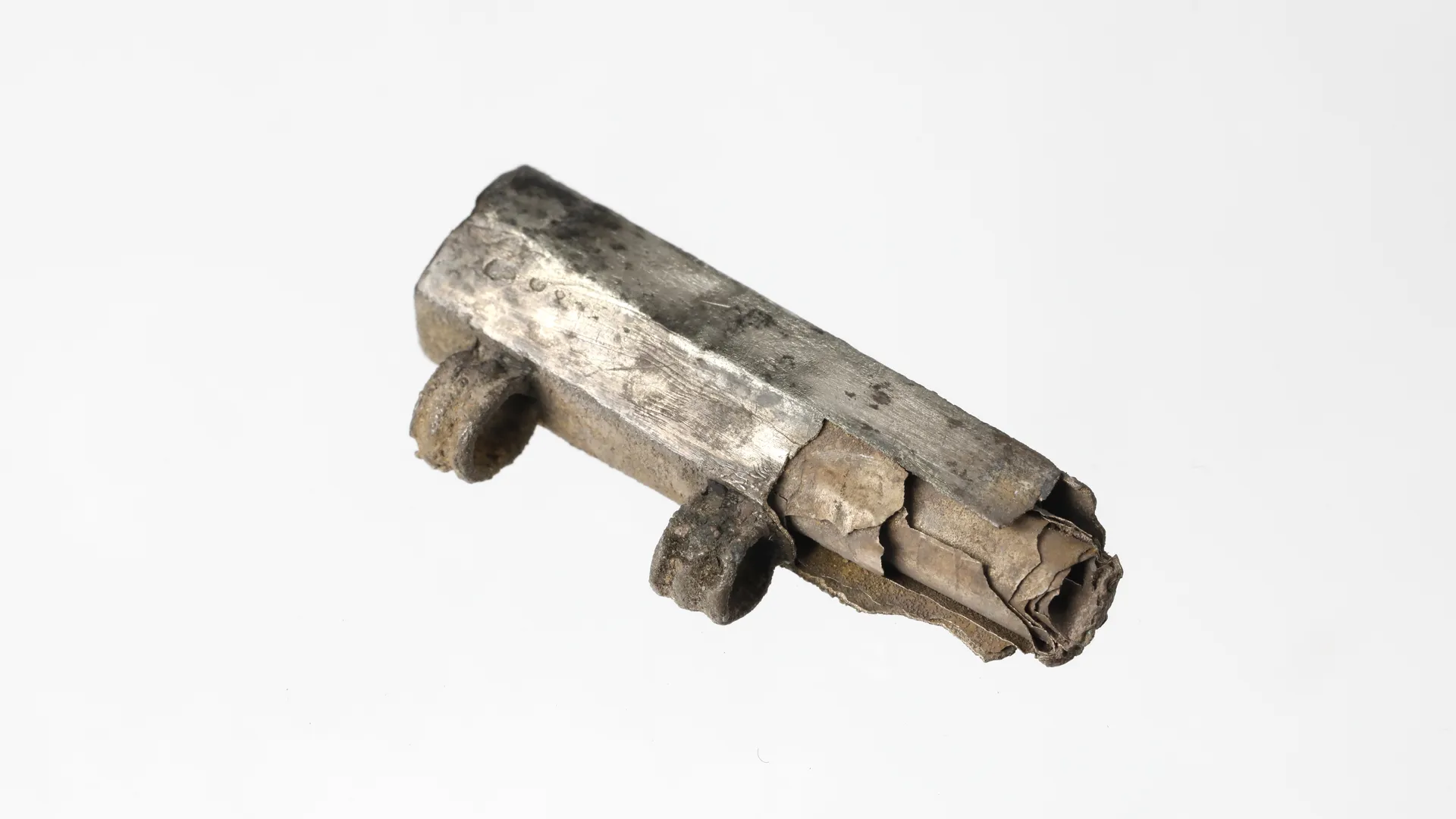 Ein kleines silbernes Röhrchen mit zwei Ösen und einem zusammengerollten Silberblech im Inneren.